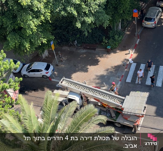 רכב עם סולם נייד חונה ברחוב ליד מעבר חצייה